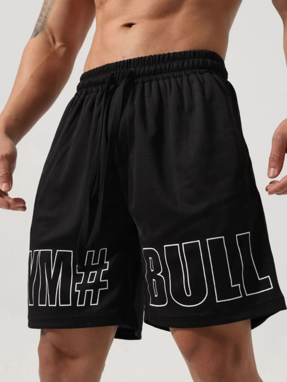 Trendsi black drawstring gym shorts for men with bold white graphic lettering on legs