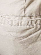 Close-up of comfortable bermuda shorts with pockets in beige fabric by Trendsi showing stitching details