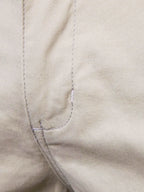 Close-up of Trendsi comfortable bermuda shorts with pockets featuring beige fabric and detailed stitching