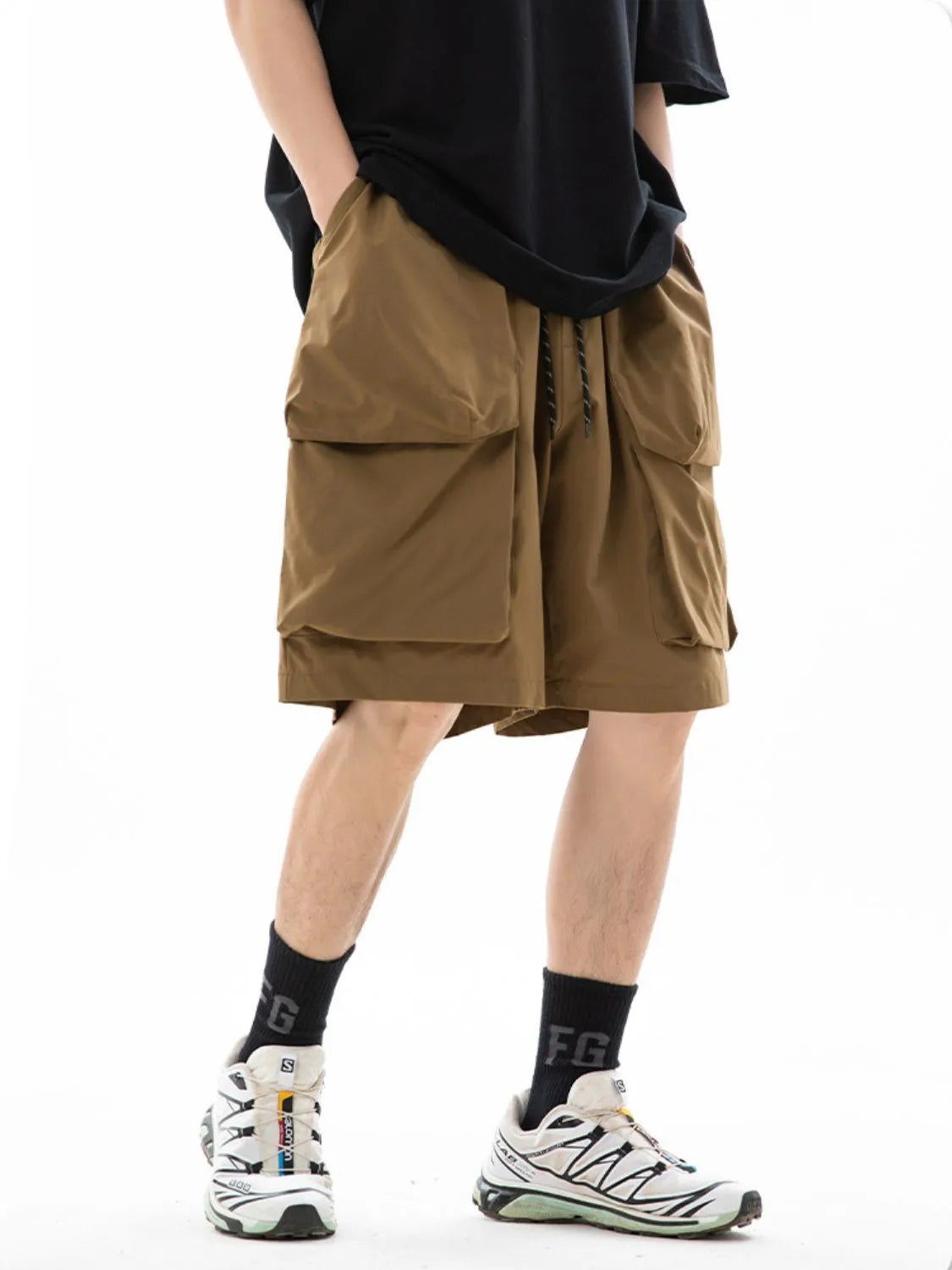 Trendsi drawstring pocketed shorts in brown worn with black shirt and white sneakers