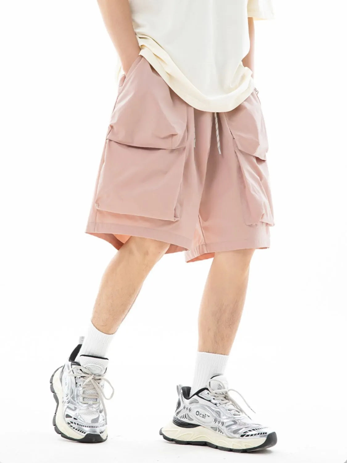 Trendsi drawstring pocketed shorts in light pink with large front pockets worn with white sneakers