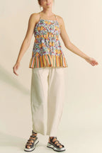 Trendsi floral smocked sleeveless top with multicolor floral print and striped hem paired with white pants