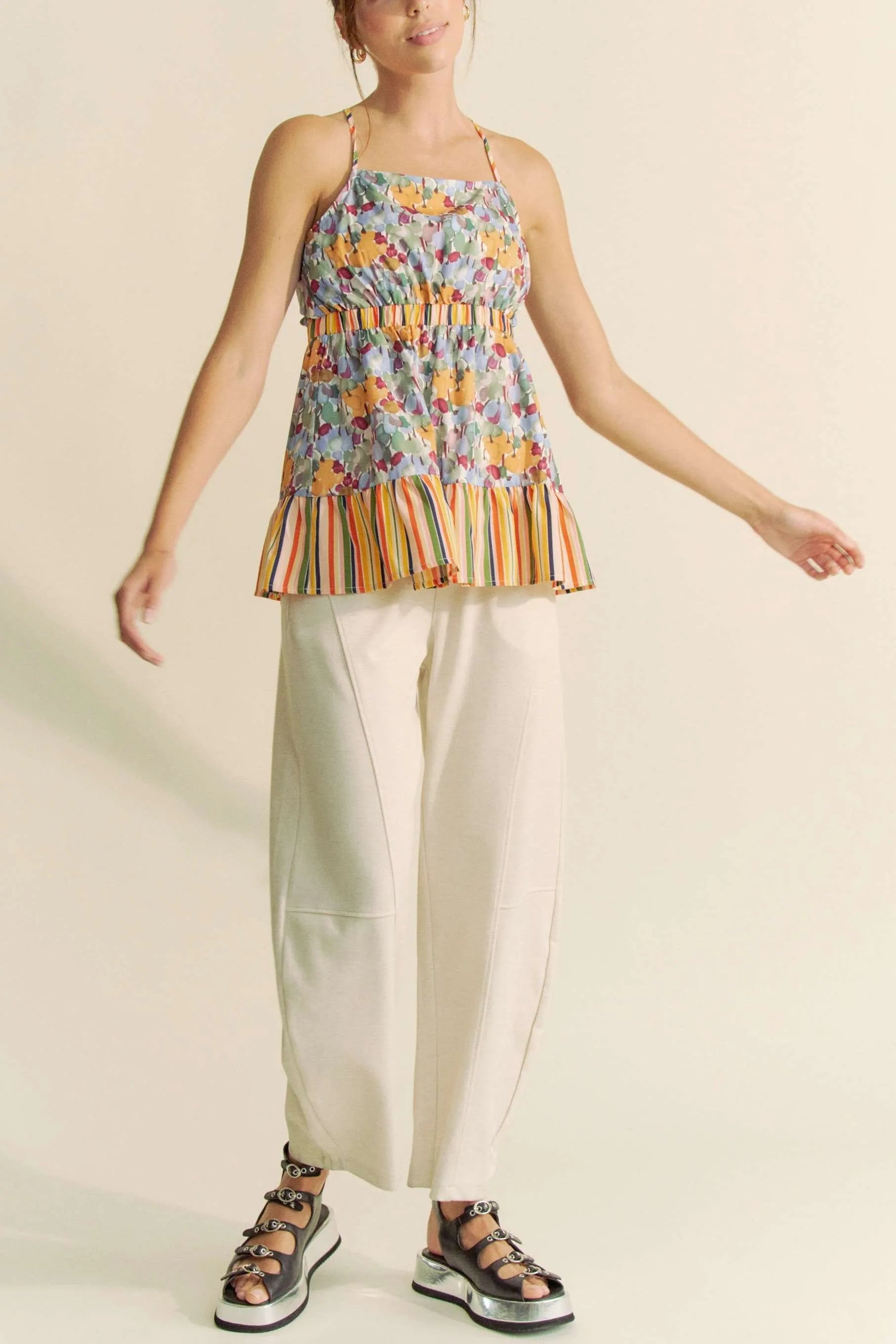 Trendsi floral smocked sleeveless top with multicolor floral print and striped hem paired with white pants