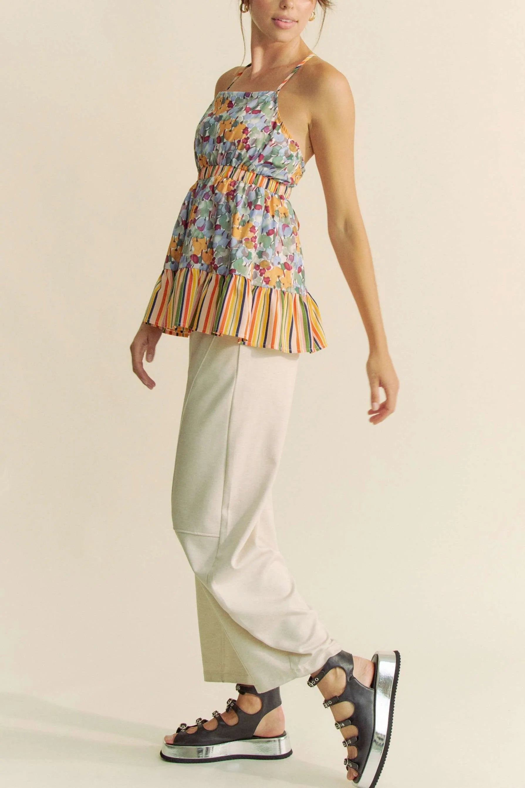 Trendsi floral smocked sleeveless top with colorful flower print and striped hem paired with beige pants