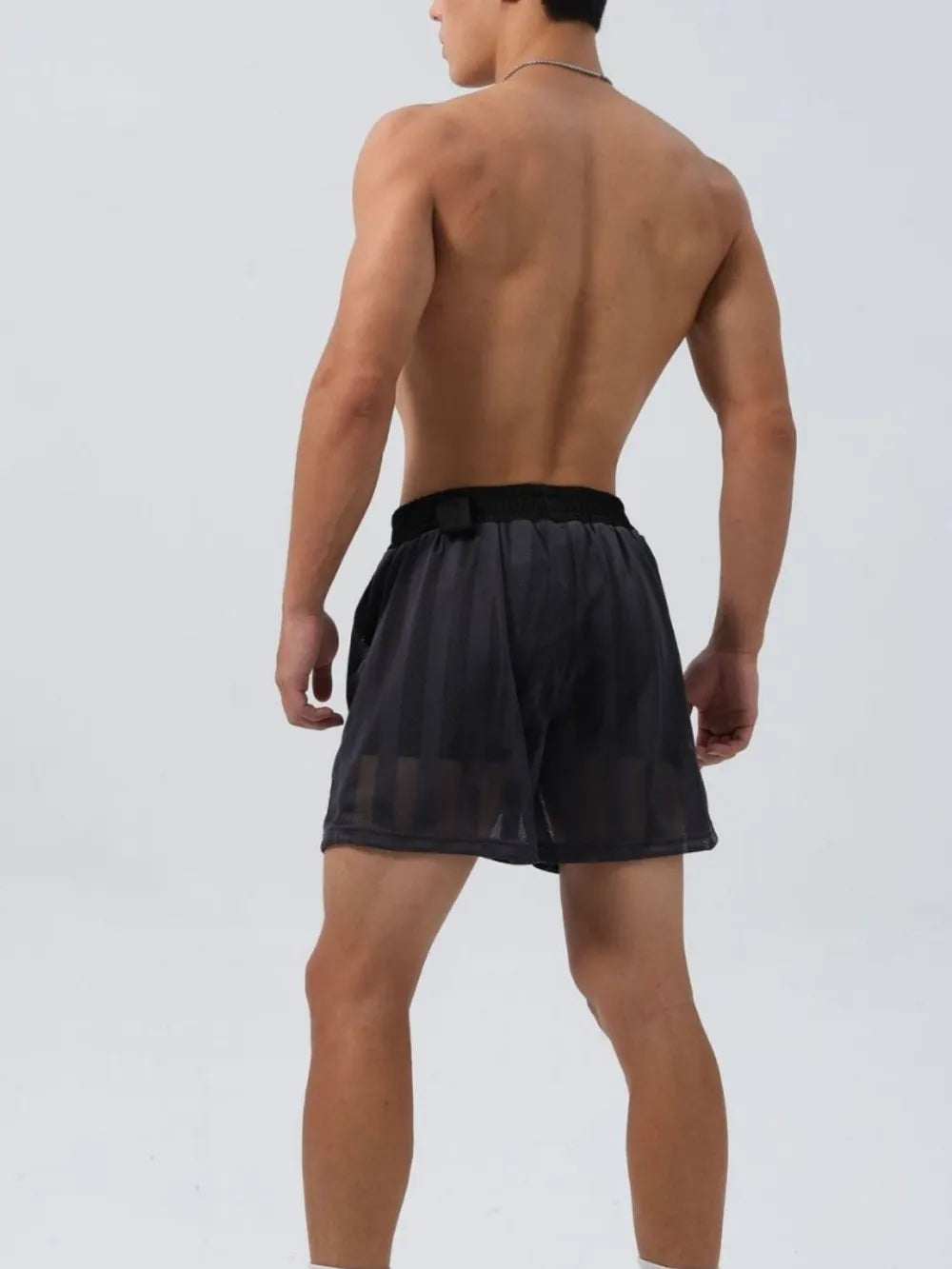 Back view of a man wearing black men's plus size shorts by Trendsi with a comfortable fit