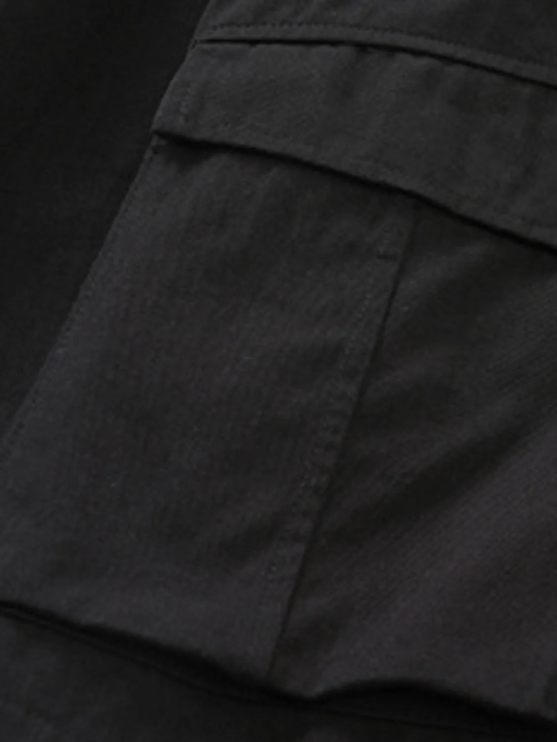 Close-up of black comfortable men's cargo shorts pocket detail by Trendsi